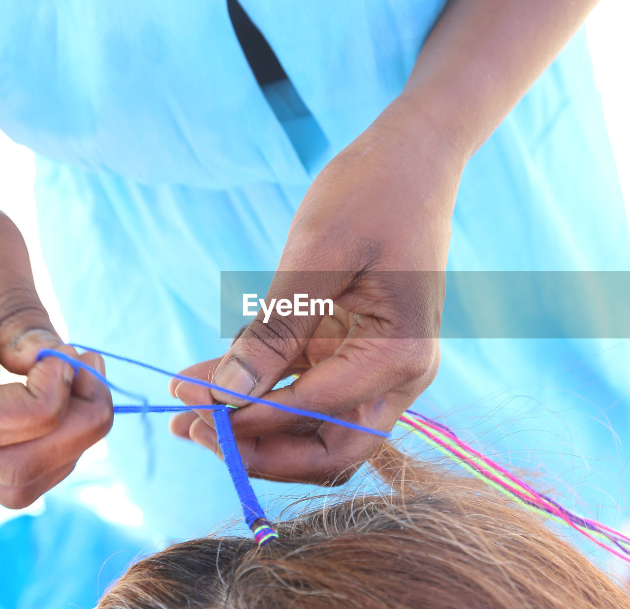 Midsection of hairdresser styling woman hair