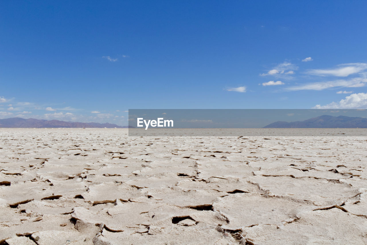 sky, land, scenics - nature, natural environment, landscape, environment, nature, horizon, sea, sand, blue, desert, cloud, climate, arid climate, beauty in nature, tranquility, no people, dry, drought, day, tranquil scene, travel, non-urban scene, barren, outdoors, horizon over land, travel destinations, water, sunlight, sunny, remote, tourism, shore, clear sky, urban skyline, plateau, beach
