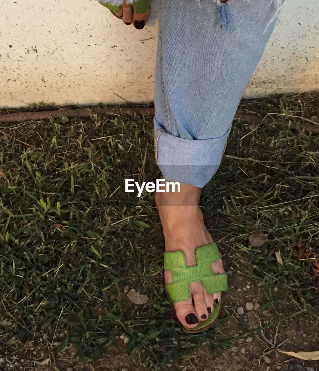 Low section of woman standing on field