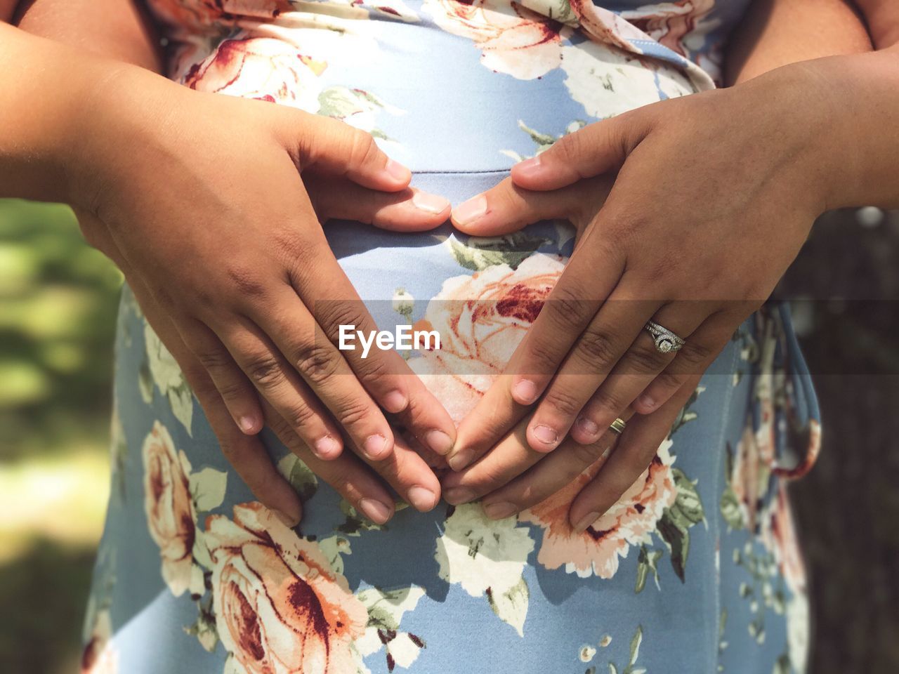 Cropped image of man with hands on pregnant wife abdomen