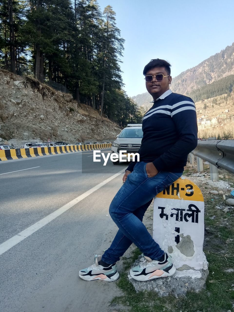 FULL LENGTH PORTRAIT OF MAN ON ROAD AGAINST TREES