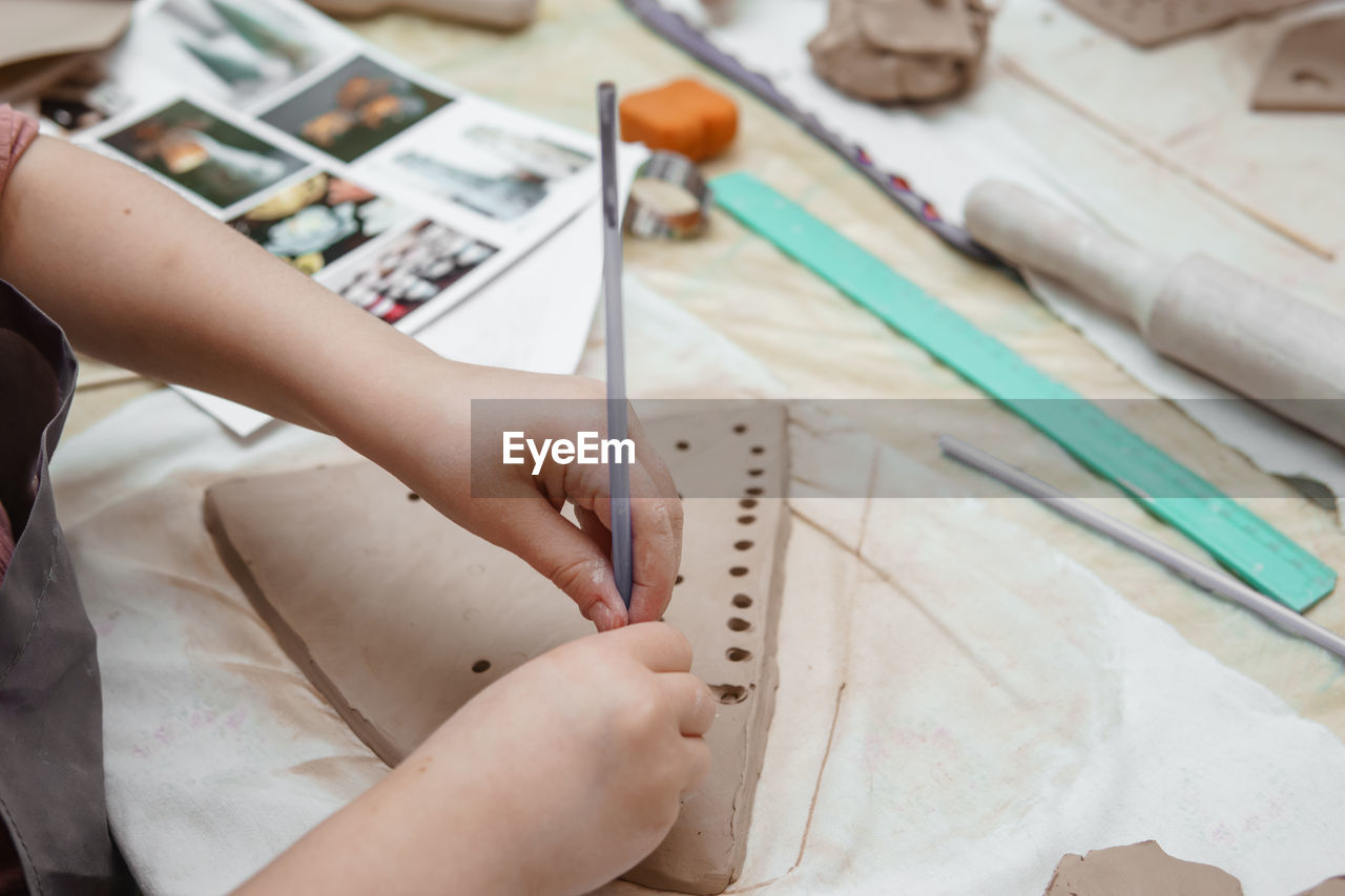 Women's hands knead clay, drawing elements of the product. production of ceramic products. 