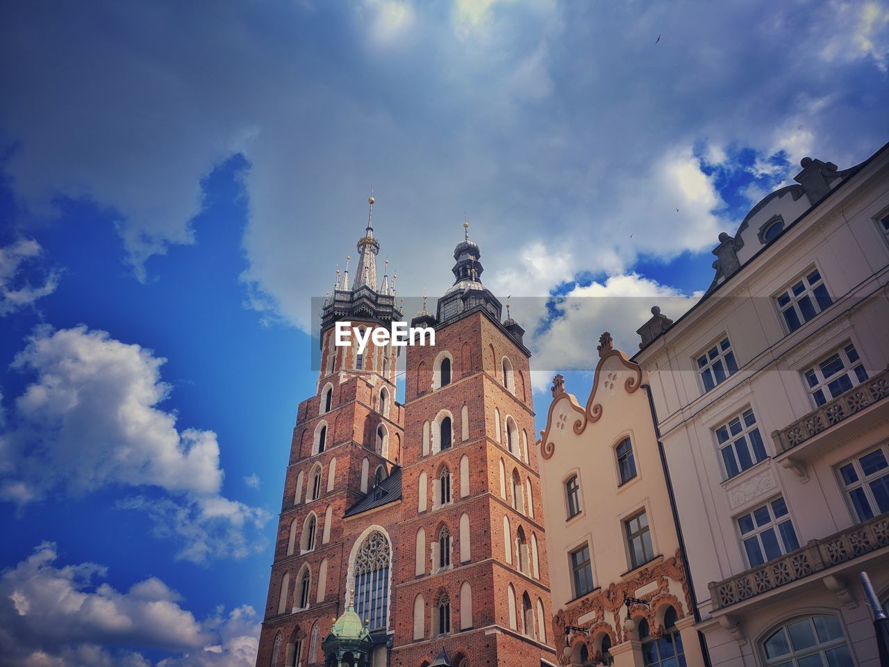 Low angle view of buildings against cloudy sky