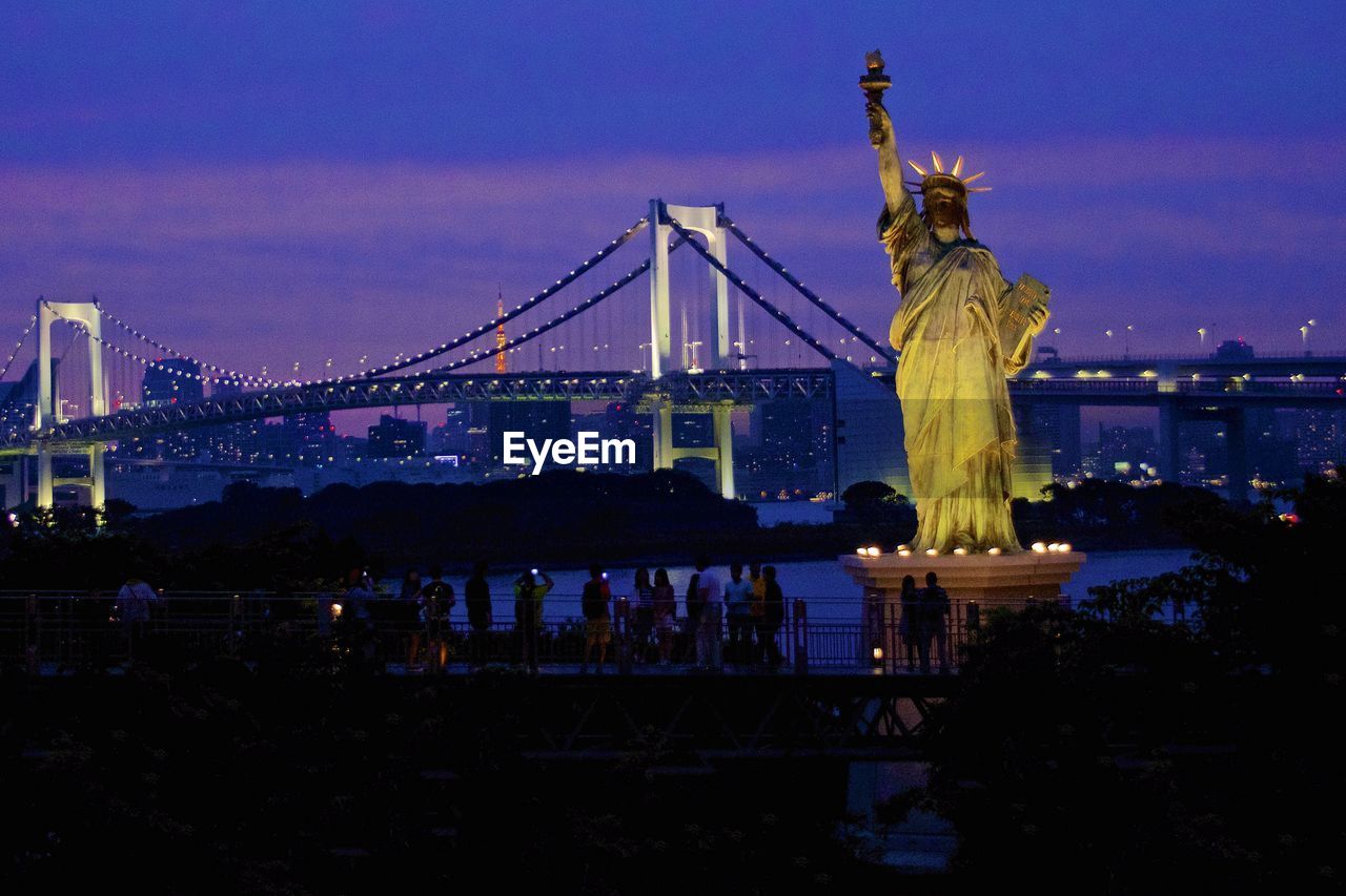 SUSPENSION BRIDGE OVER RIVER AT DUSK