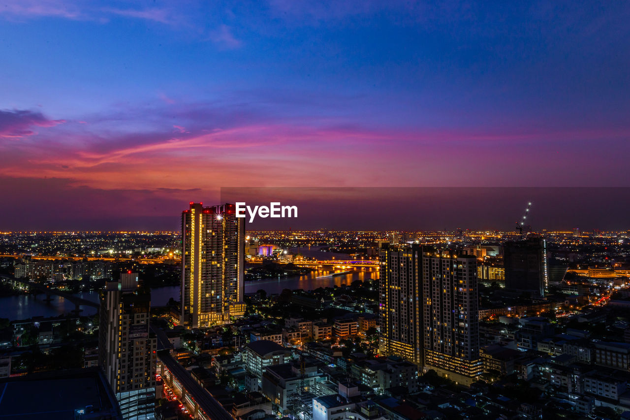 High angle view of illuminated buildings against sky at night