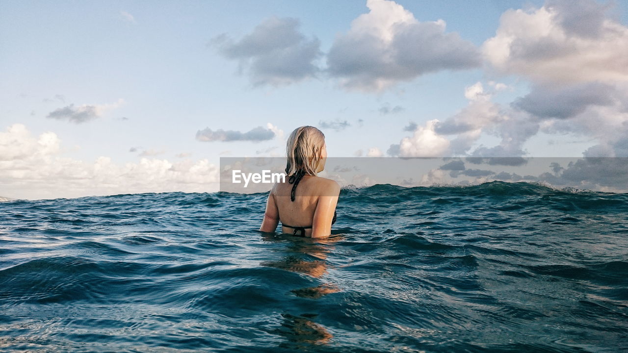 Rear view of woman swimming in ocean