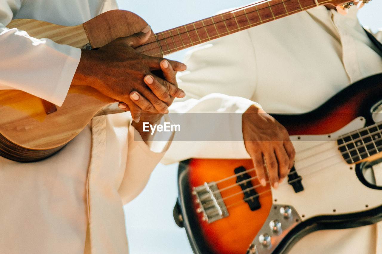 Close-up of hands holding guitars