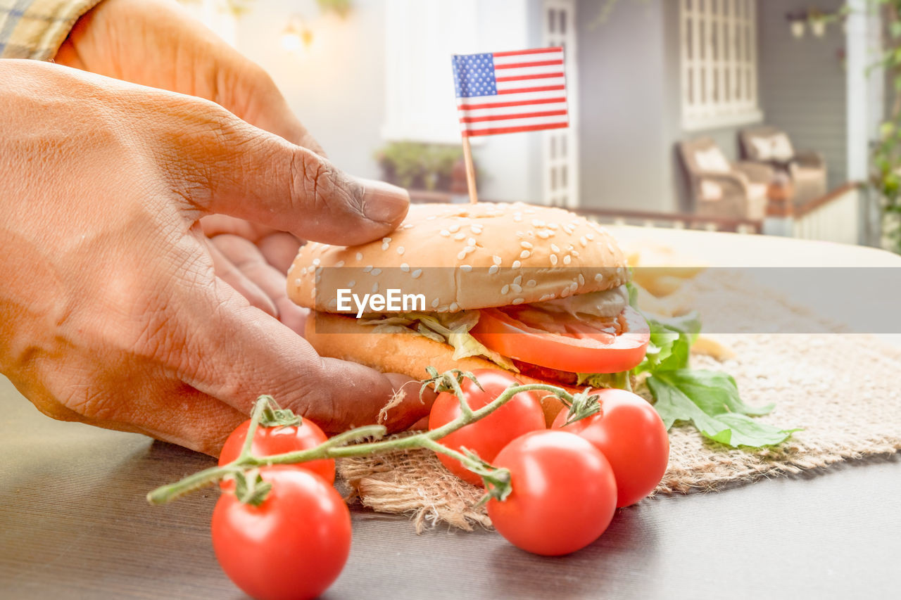 The homemade hamburger with fresh vegetables, french fries, beef, onion, tomato