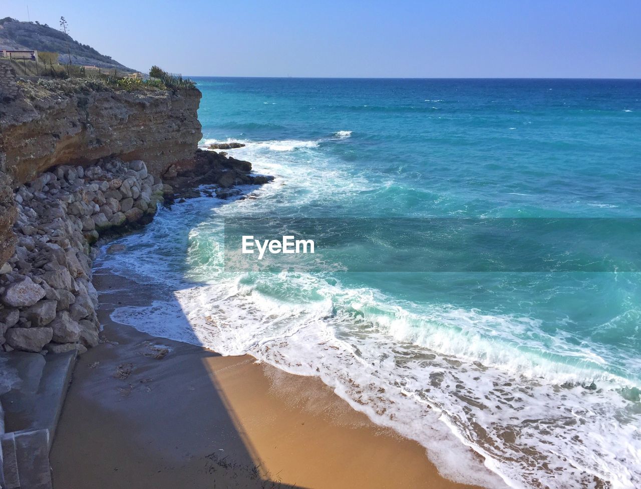 Scenic view of cliff by sea