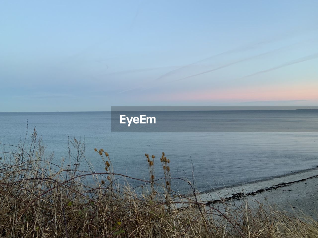 SCENIC VIEW OF BEACH AGAINST SKY DURING SUNSET