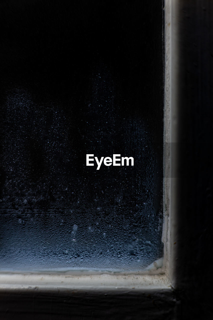 CLOSE-UP OF RAINDROPS ON WINDOW GLASS