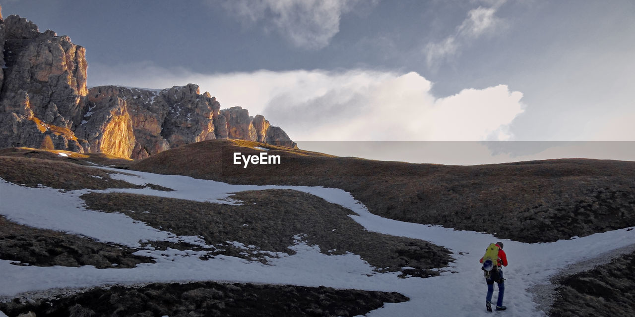 WOMAN STANDING ON MOUNTAIN AGAINST SKY