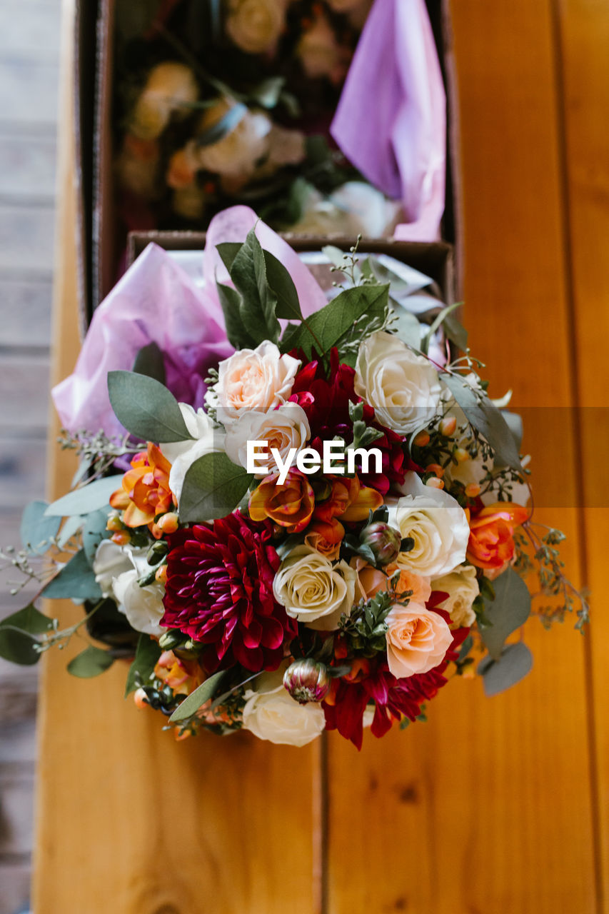 CLOSE-UP OF BOUQUET WITH ROSES AGAINST INDOORS