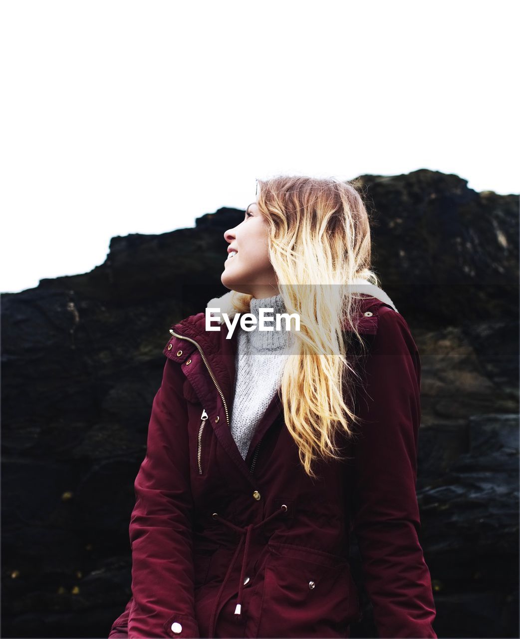 Low angle view of woman looking up against clear sky