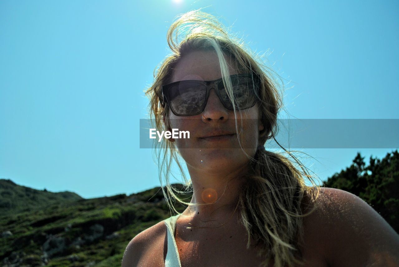 Woman wearing sunglasses against clear sky