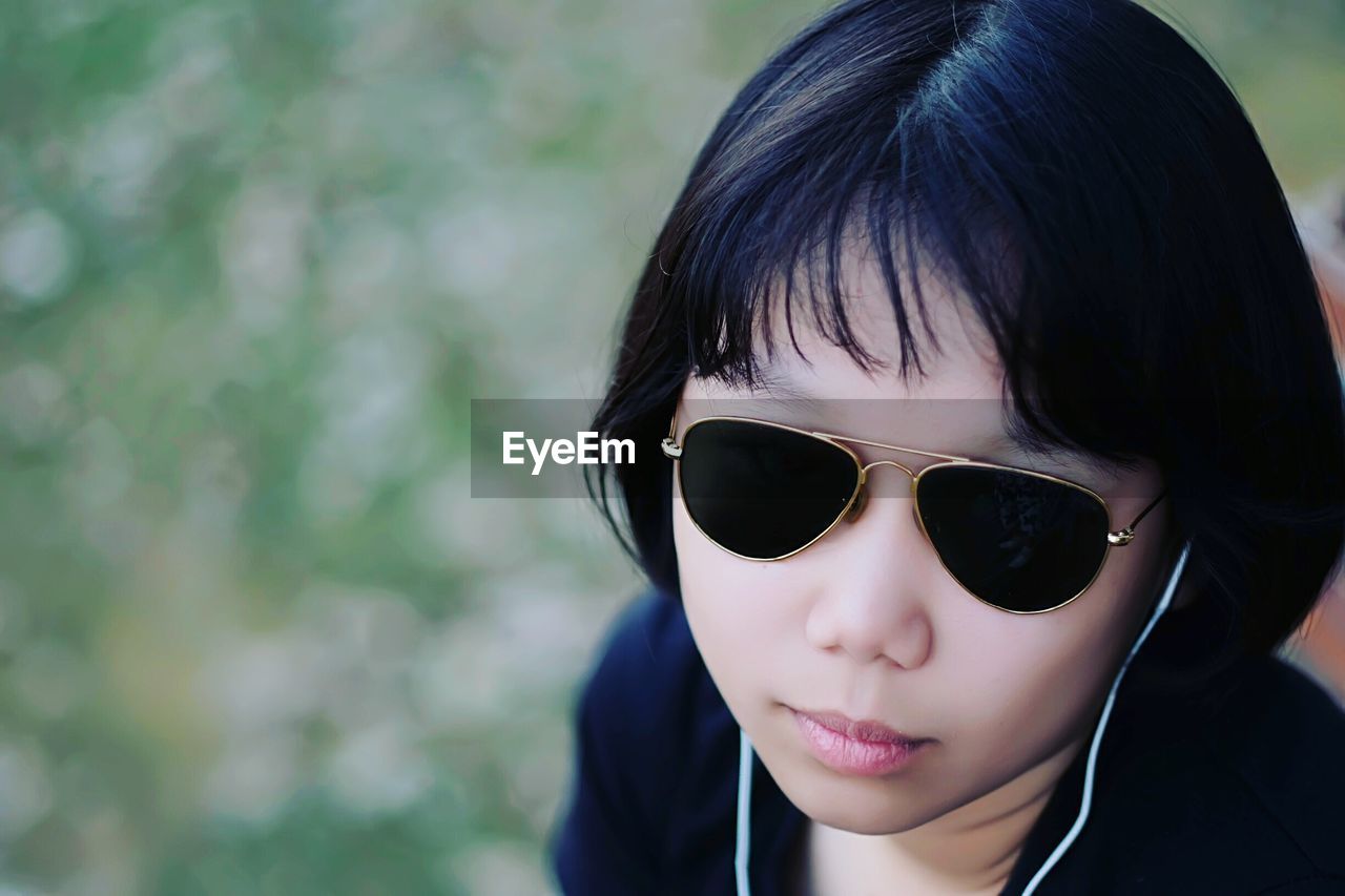 High angle view of teenage girl wearing sunglasses while listening music