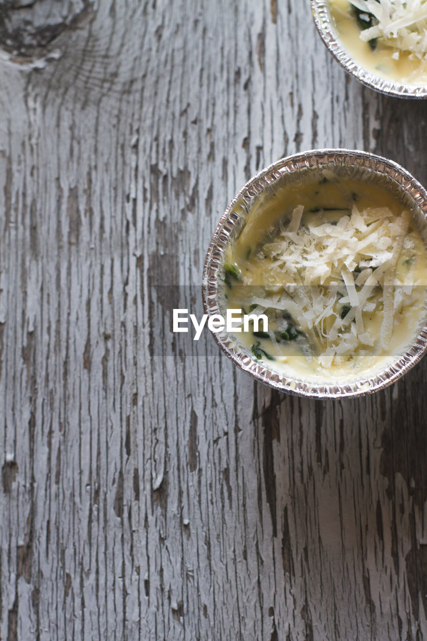 Directly above shot of casseroles with eggs and parmesan cheese