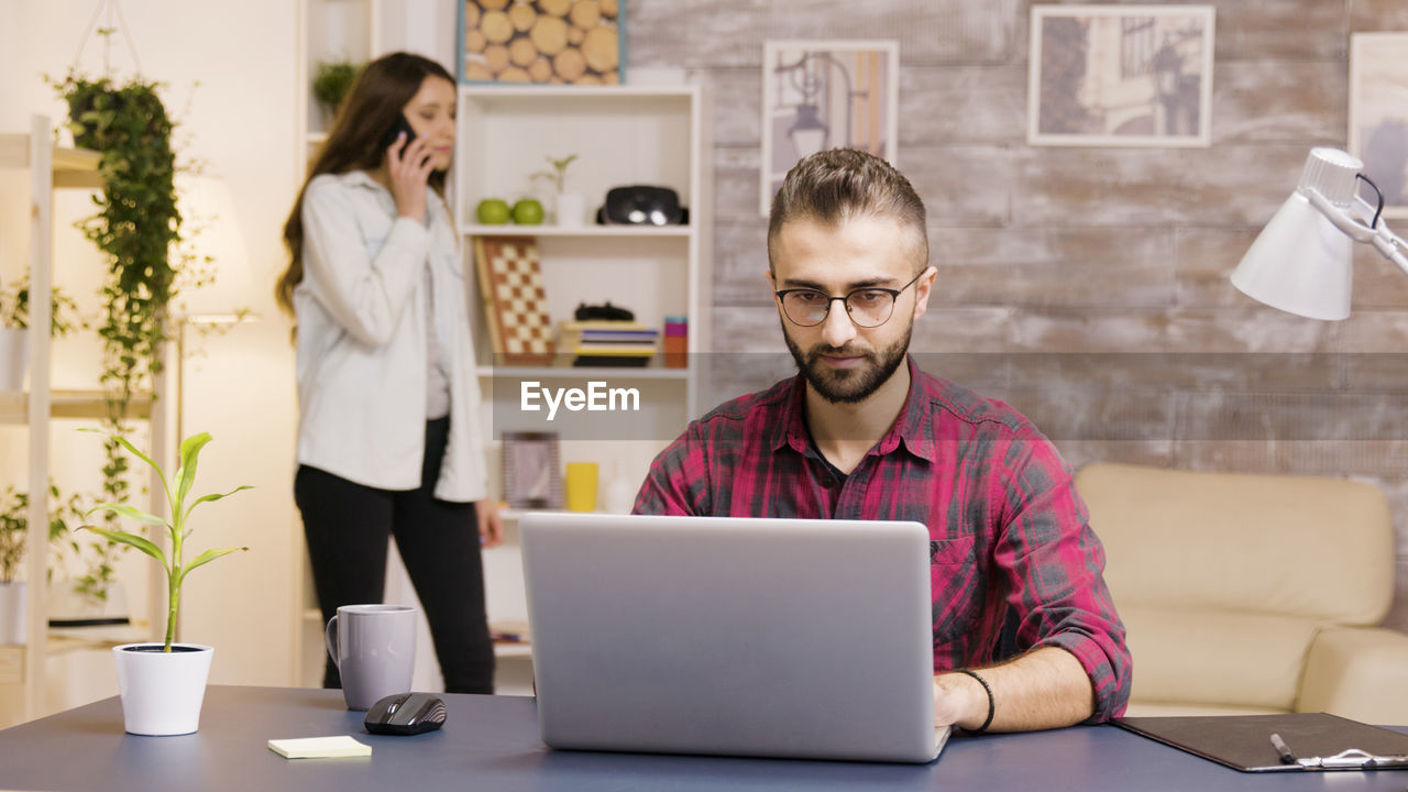 Young woman using laptop while sitting at office