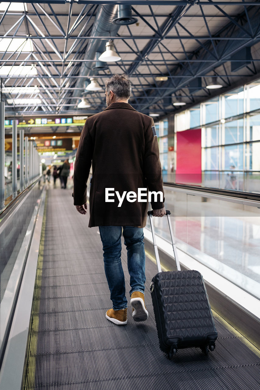 Rear view of man walking in airport