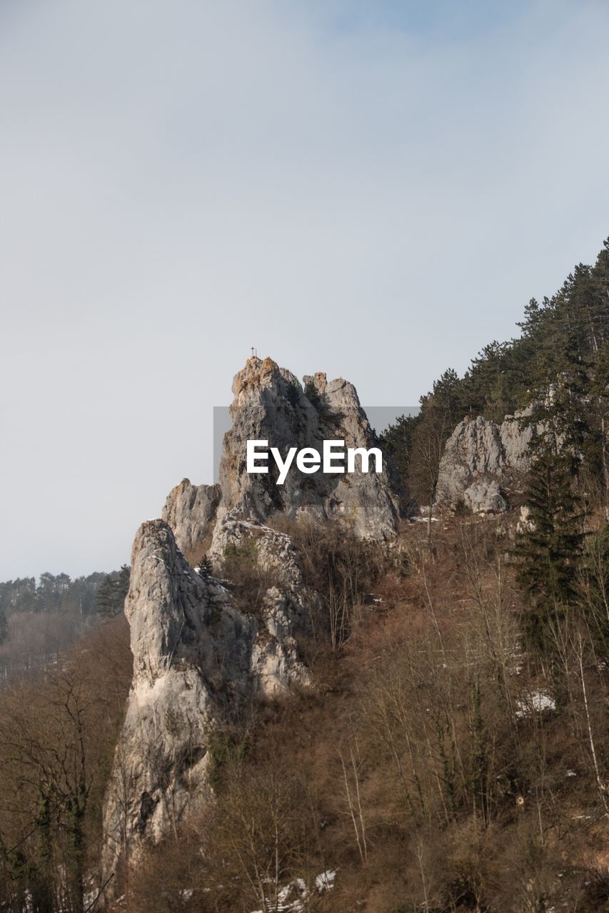 Scenic view of rocks amidst trees against sky