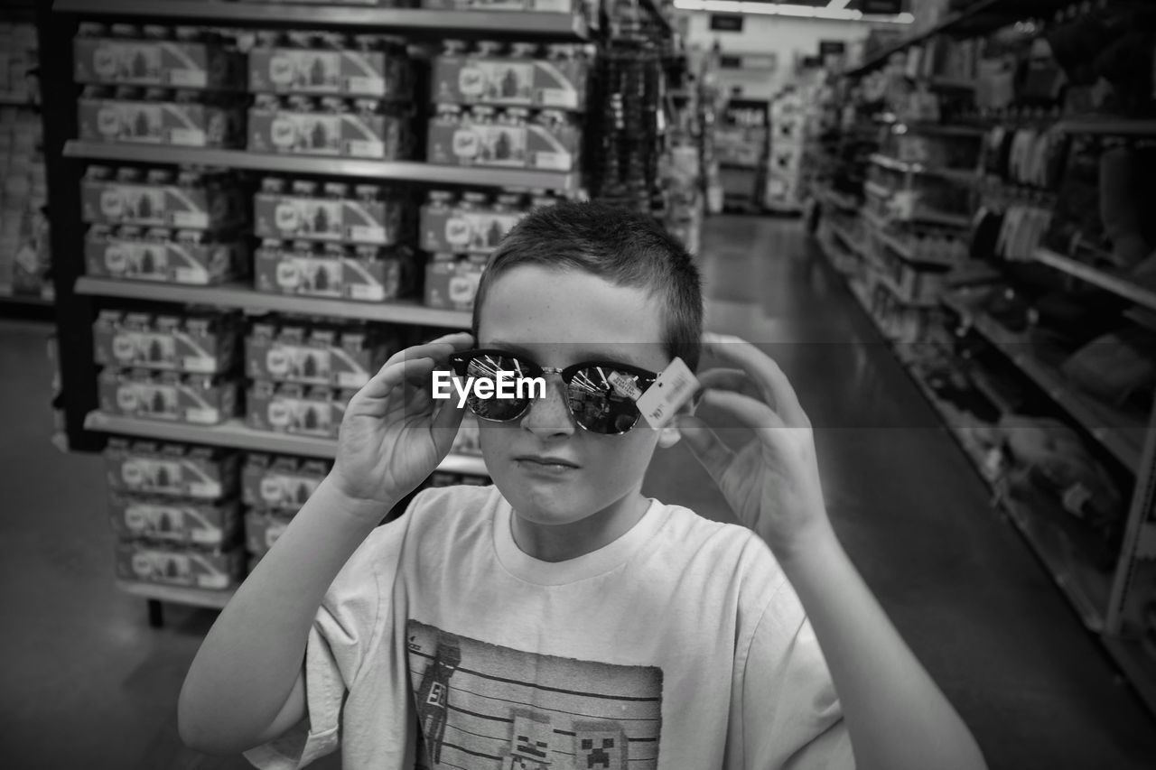 Portrait of boy wearing sunglasses while standing in store