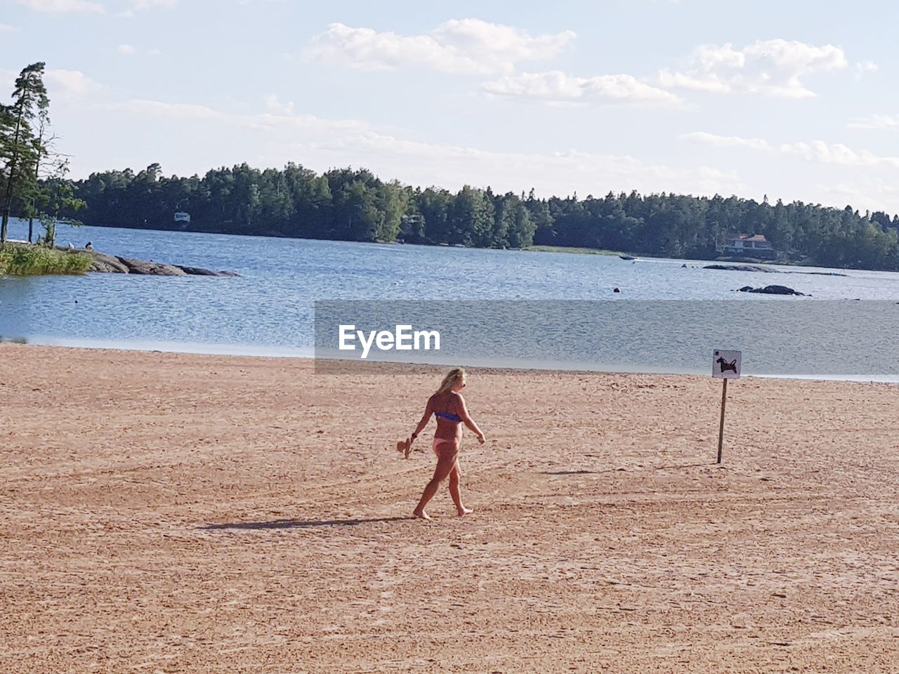 BOY ON BEACH AGAINST SKY