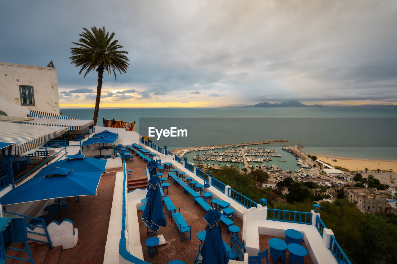 water, sea, sky, vacation, beach, tropical climate, architecture, nature, palm tree, travel destinations, land, cloud, sunset, travel, built structure, building exterior, ocean, holiday, trip, city, tourism, scenics - nature, tree, transportation, environment, coast, building, no people, outdoors, coastline, nautical vessel, beauty in nature, island, landscape, house, plant, tourist resort, tranquility, dusk, blue, harbor