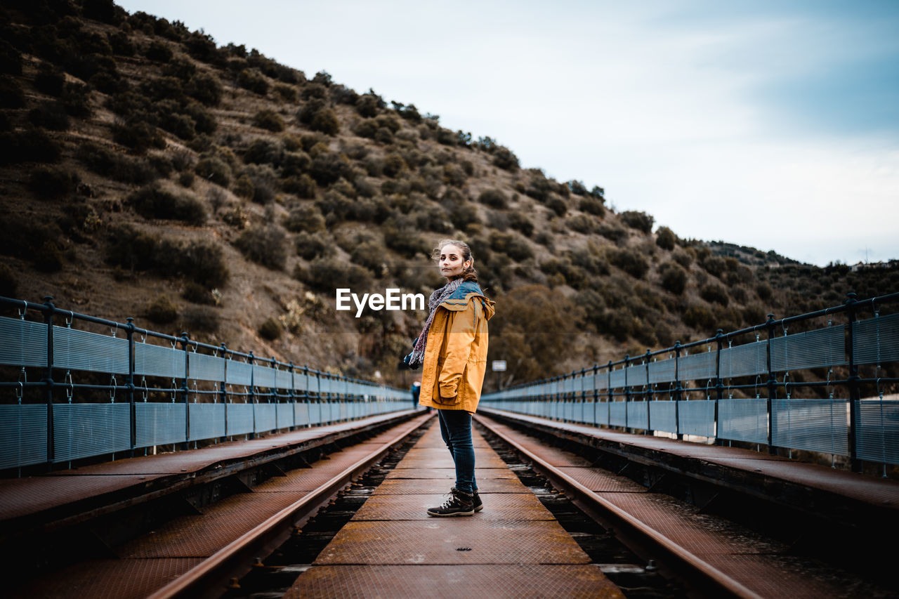 MAN STANDING ON RAILROAD TRACK