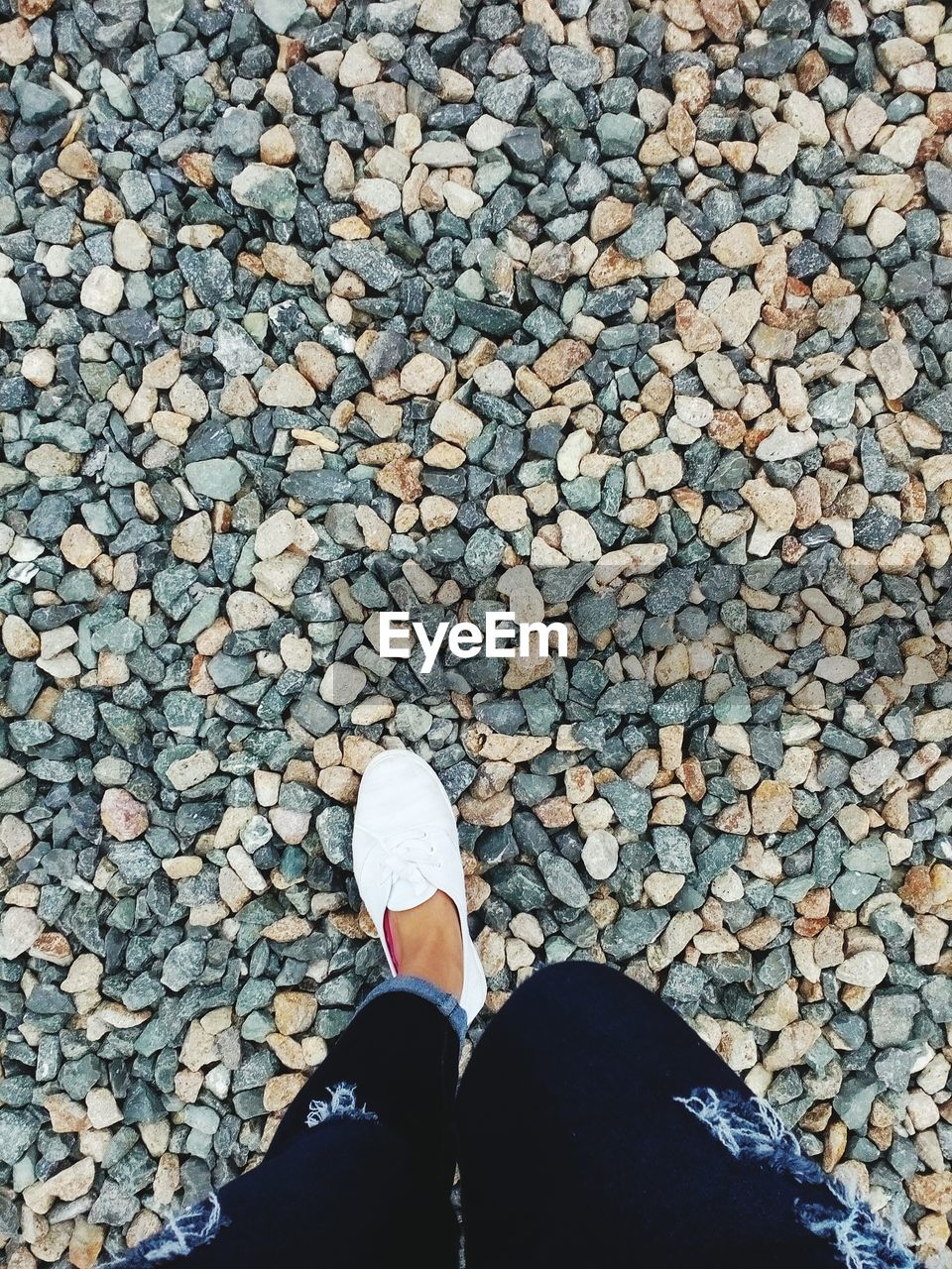 LOW SECTION OF PERSON STANDING ON TILED FLOOR