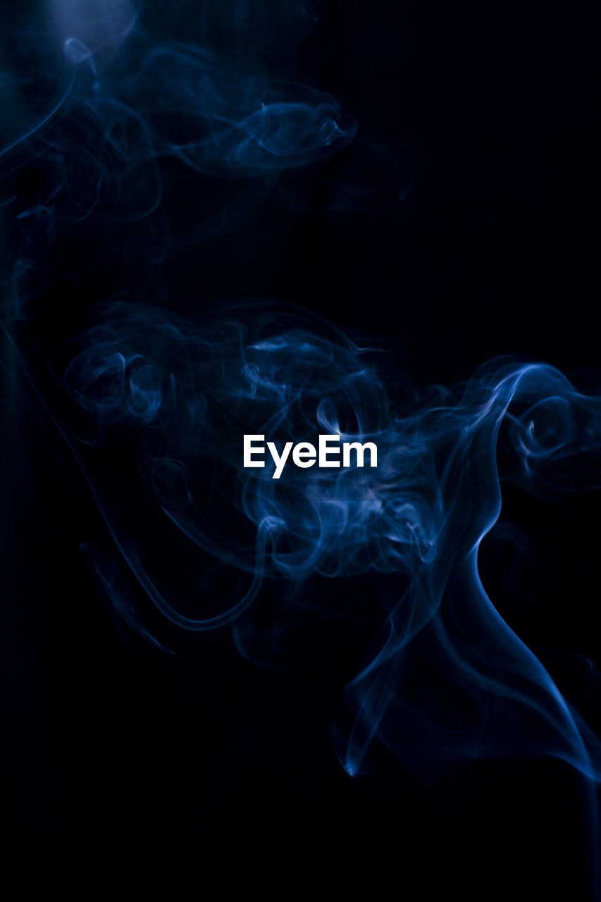 Close-up of blue smoke against black background