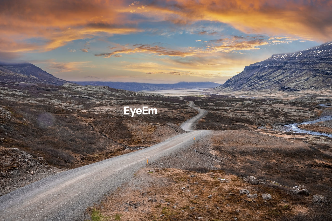 View of road amidst volcanic landscape at eastfjords against dramatic sky