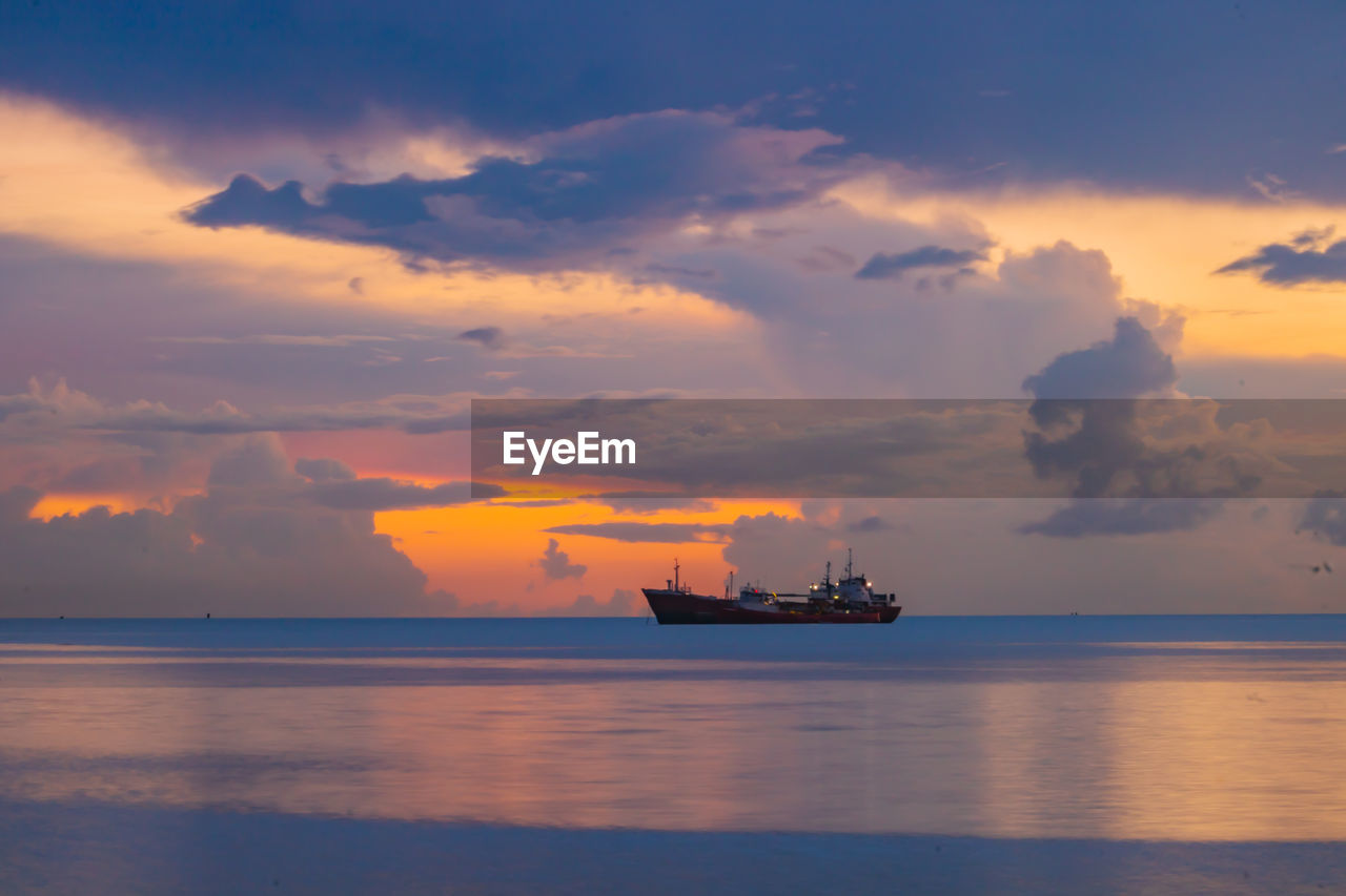 water, sea, sky, nautical vessel, horizon, cloud, sunrise, transportation, ocean, dawn, ship, mode of transportation, morning, nature, coast, bay, vehicle, shore, reflection, beauty in nature, horizon over water, afterglow, scenics - nature, business, sailing, outdoors, shipping, industry, container ship, travel, no people, freight transportation, boat, environment, watercraft, seascape, dramatic sky, tranquility