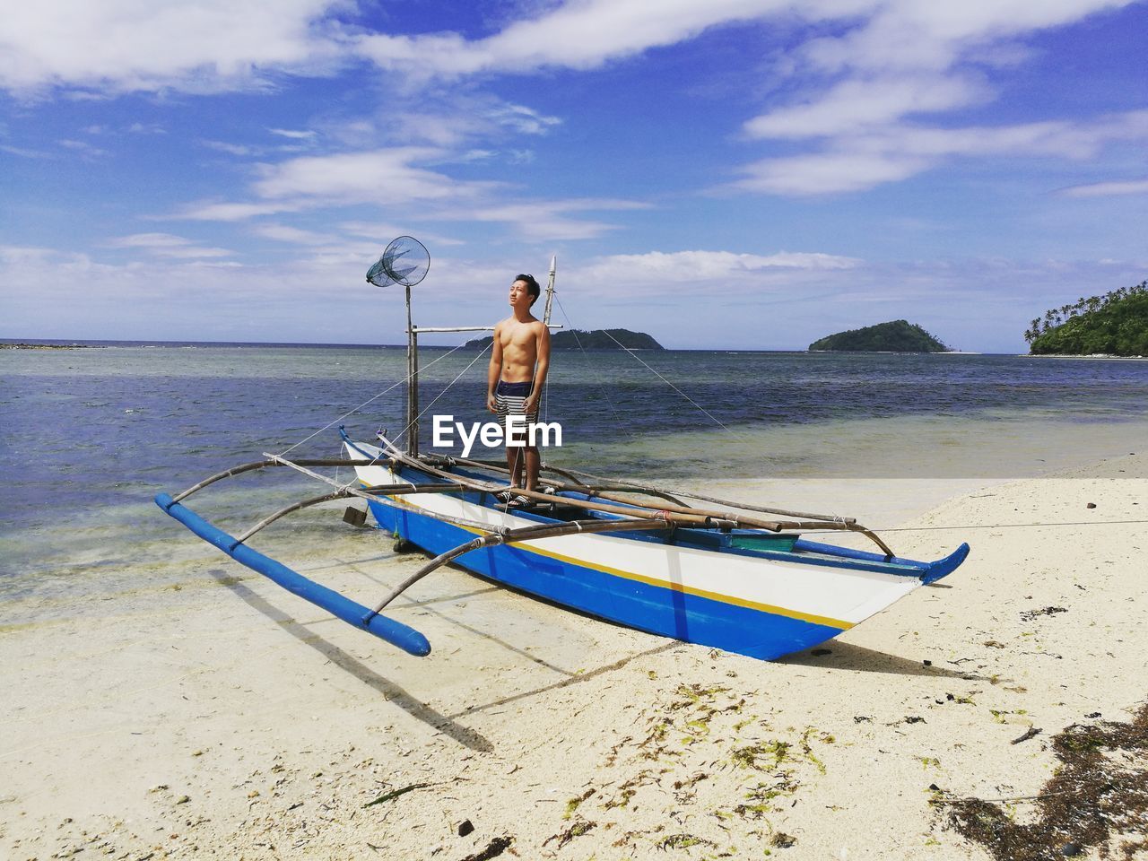 MAN ON SHORE AGAINST SKY