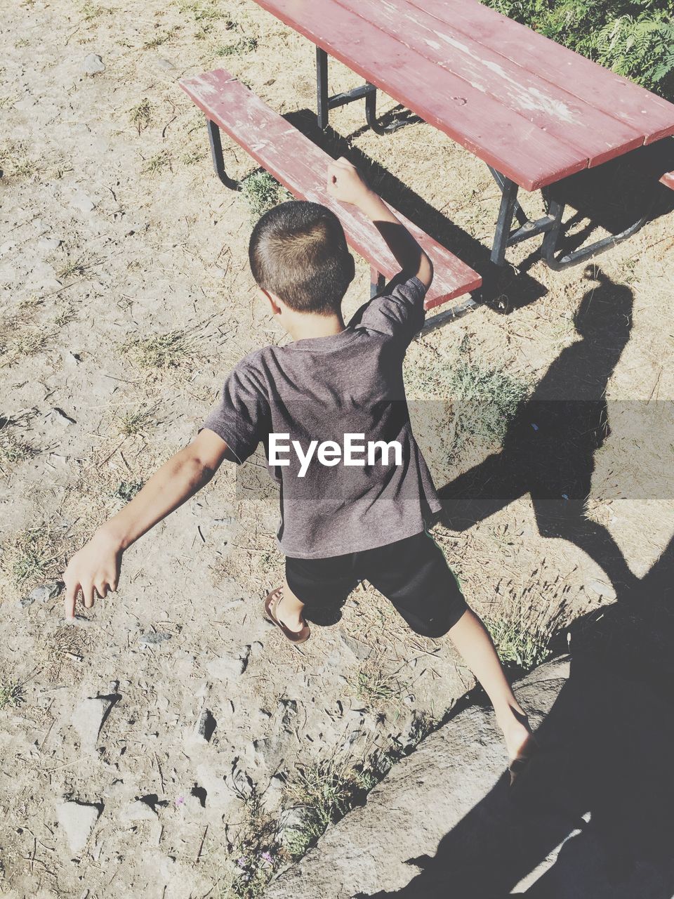 LOW SECTION OF BOY PLAYING ON PAVING STONE