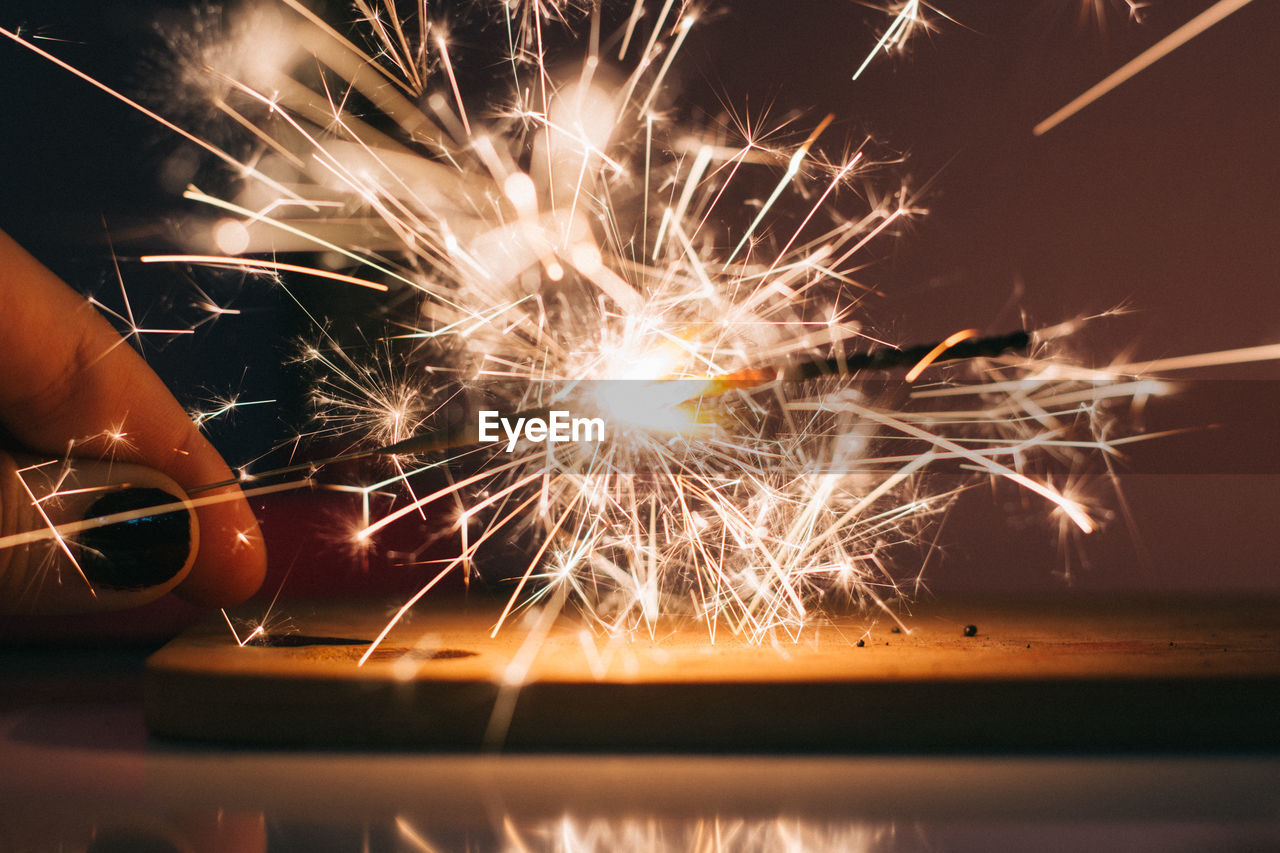 Cropped image of woman hand holding sparkler