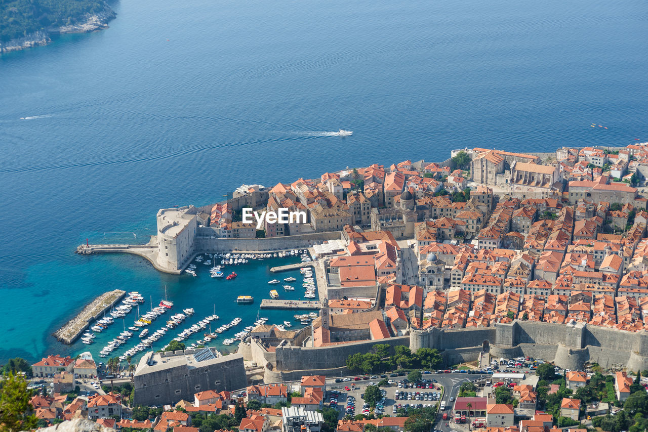 High angle view of cityscape by sea against sky