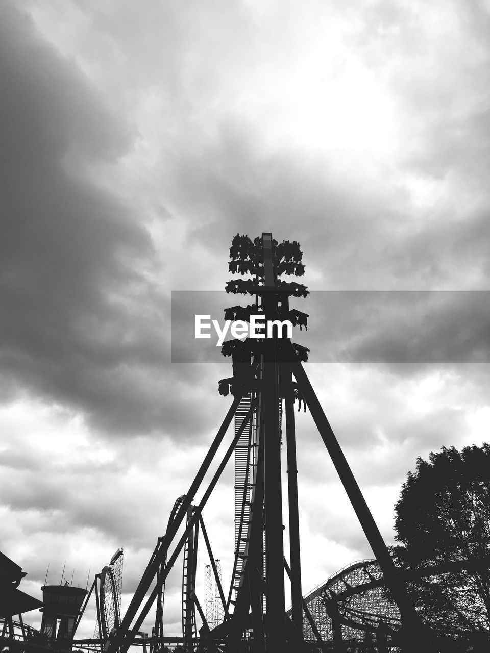 LOW ANGLE VIEW OF AMUSEMENT PARK AGAINST CLOUDY SKY