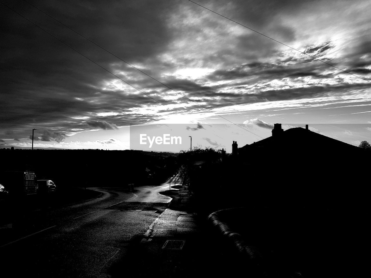 ROAD BY SILHOUETTE CITY AGAINST SKY DURING SUNSET