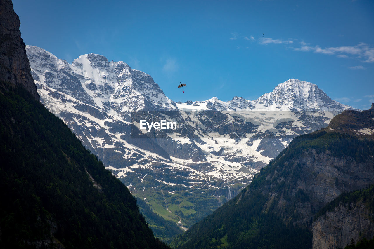 Low angle view of skydiver and mountains in the sky over lauterbrunnen valley.