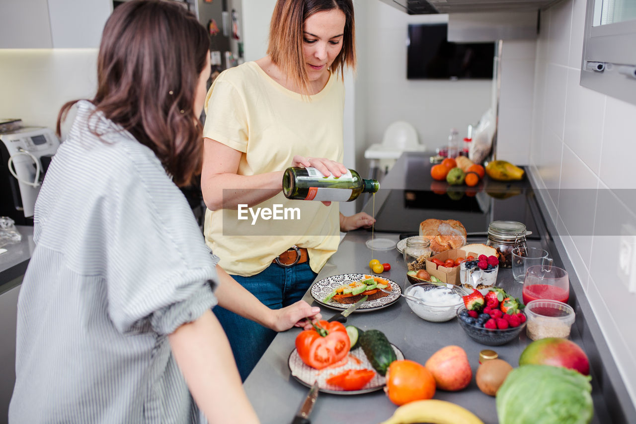 Midsection of woman standing on table at home