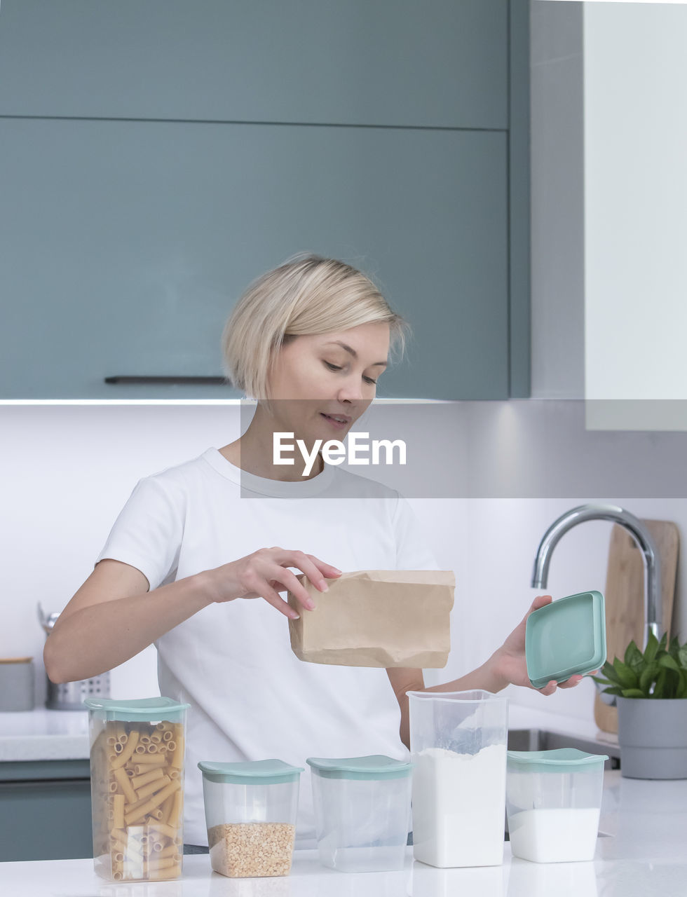 Portrait of female friends washing hands in kitchen