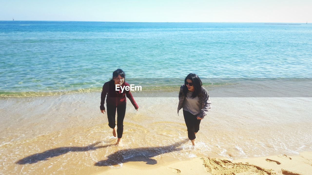 Mother with son wearing sunglasses at beach