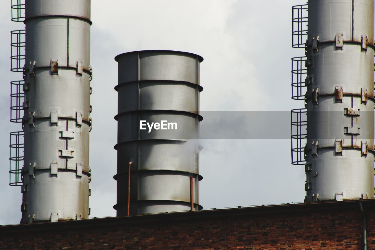 LOW ANGLE VIEW OF SMOKE STACK AGAINST SKY AT FACTORY