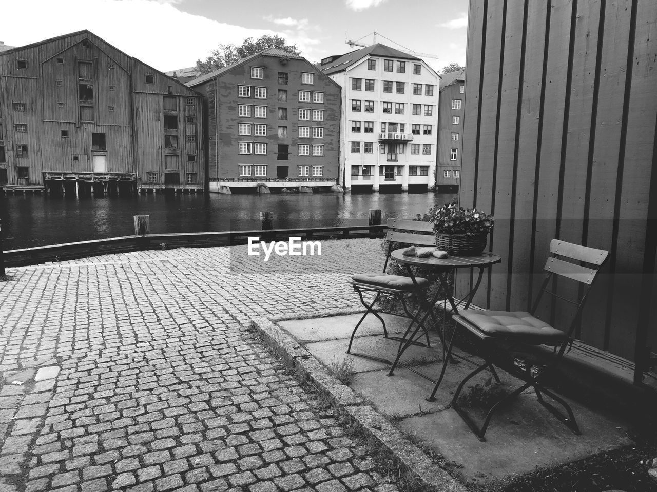 Empty chairs and table by footpath