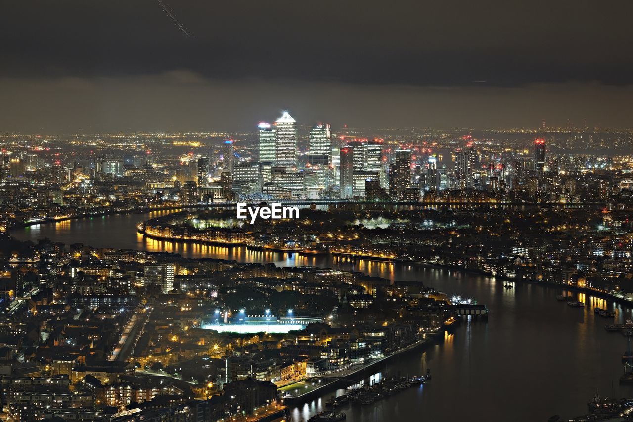 Aerial view of buildings and river at night