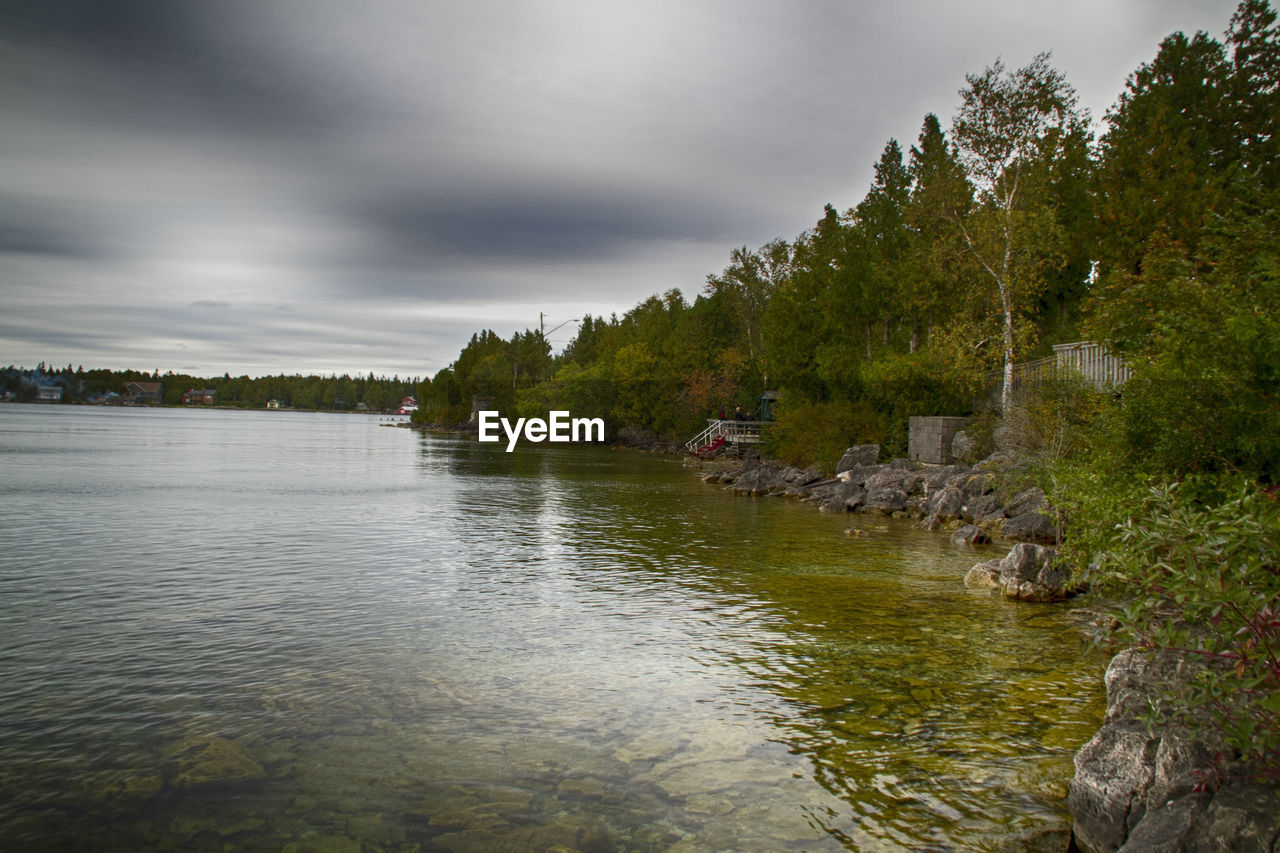 SCENIC VIEW OF LAKE BY TREES IN FOREST AGAINST SKY