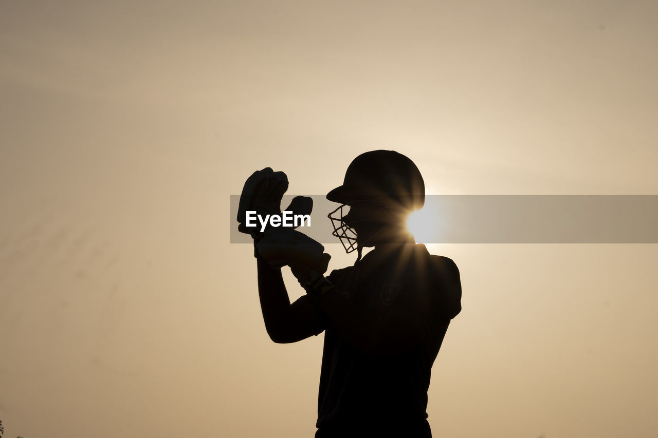 Silhouette of a cricket player getting ready before the match in the evening. indian cricketer