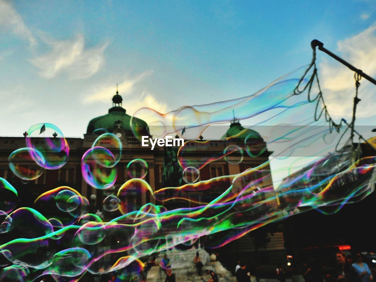 Low angle view of bubbles against rainbow in sky