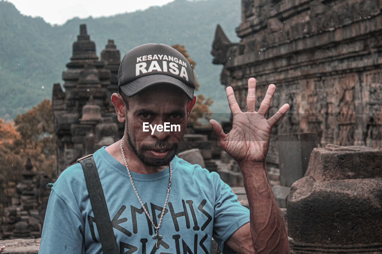 PORTRAIT OF A MAN STANDING AT HISTORICAL BUILDING