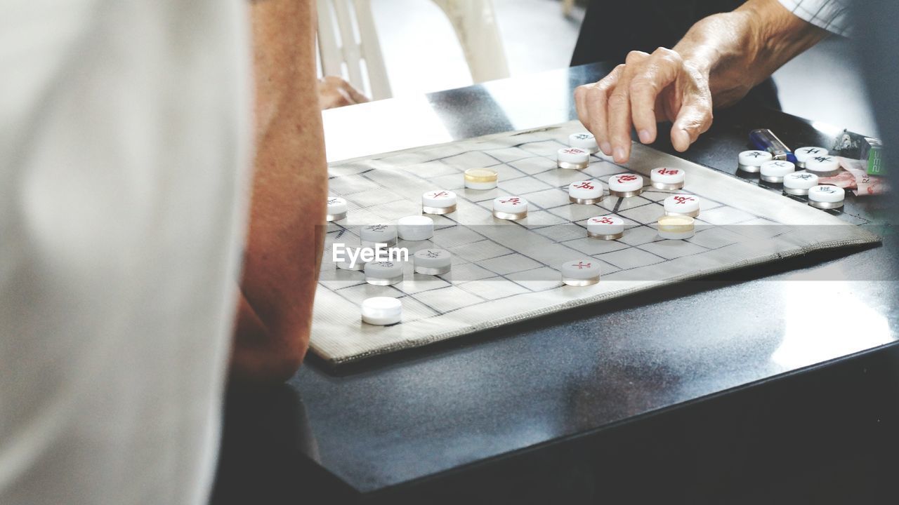 People playing checkers on table